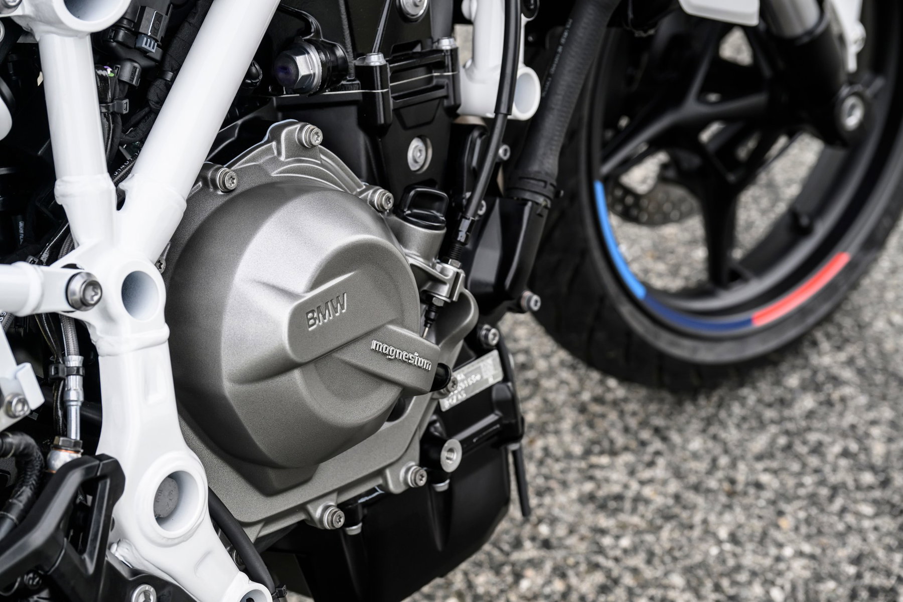 BMW F 450 R ab 6.490 Euro: Die A2-BMW unterbietet Aprilias Tuono 457 4 BMW F 450 R 2027 – Detailansicht des Reihenzweizylinders mit Magnesium-Kupplungsdeckel im weißen Stahlrahmen