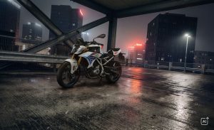 BMW F 450 R 2027 – M Sport in Snaefell Weiß / M Motorsport, Standaufnahme schräg von vorn auf nassem Parkdeck bei Nacht (KI-generiertes BMW-Pressebild)