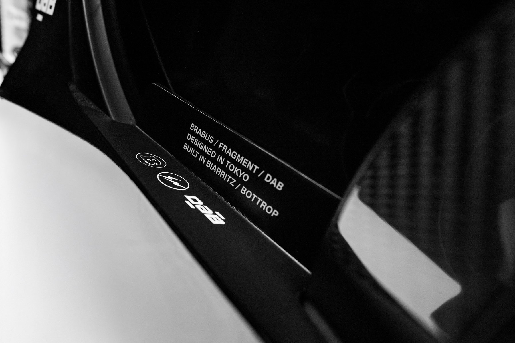 BRABUS URBAN E FRAGMENT EDITION: Almost 15,000 Euros More for Fujiwara's Design 4 BRABUS Urban-E Fragment Edition 2026 – Plakette „Designed in Tokyo – Built in Biarritz / Bottrop“ neben dem weißen Sitz