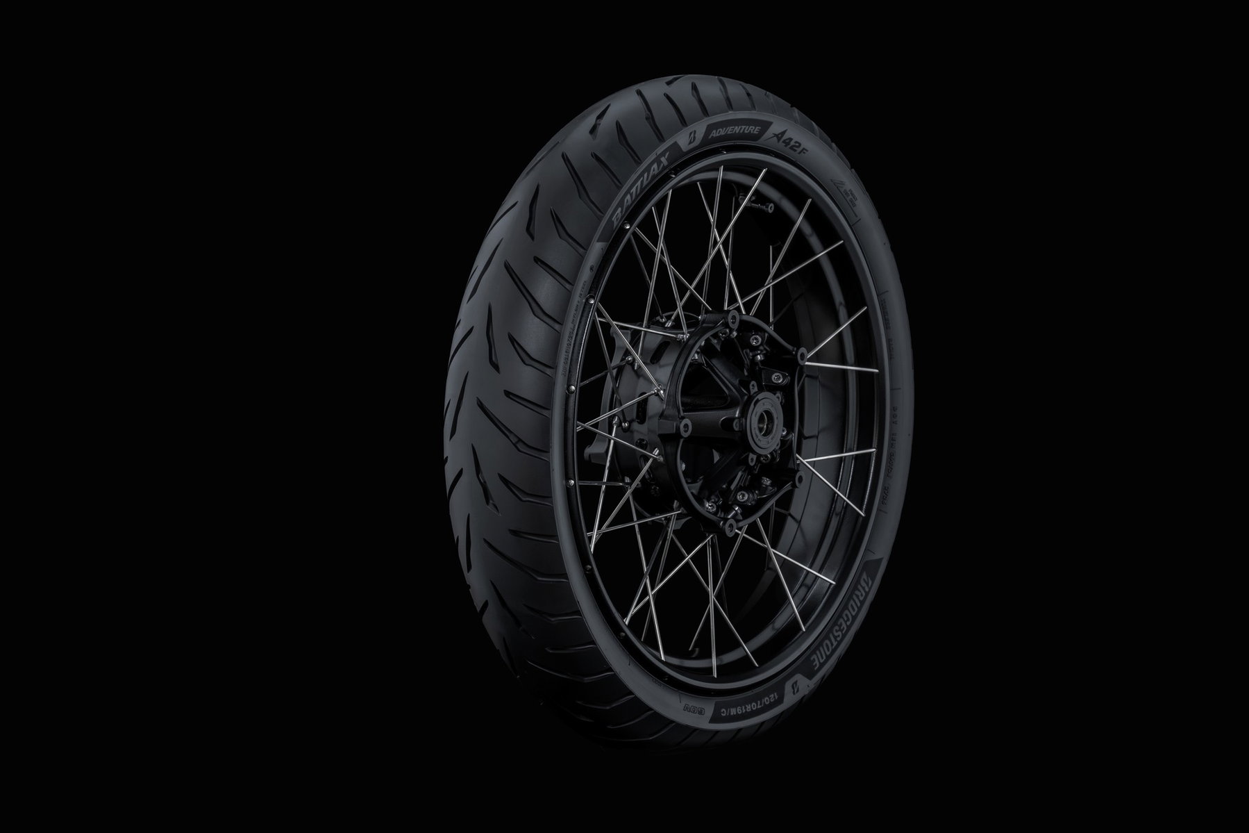 Bridgestone Battlax Adventure A42 Vorderreifen – Studioaufnahme auf schwarzem Speichenrad vor dunklem Hintergrund