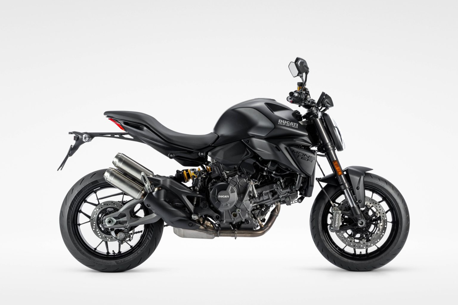 Ducati Monster Dark: Die günstigste Monster spart am Quickshifter Ducati Monster Dark 2027 – Seitenansicht von rechts in mattschwarzer Lackierung Dark Stealth mit schwarzen Felgen und unlackierten Auspuff-Endkappen im Studio