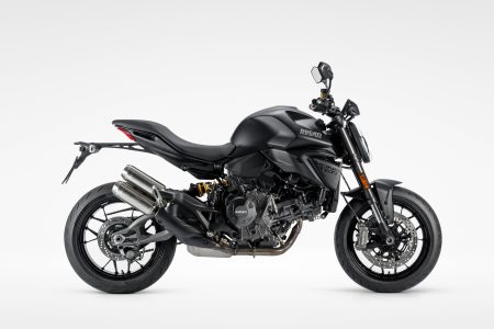 Ducati Monster Dark 2027 – Seitenansicht von rechts in mattschwarzer Lackierung Dark Stealth mit schwarzen Felgen und unlackierten Auspuff-Endkappen im Studio