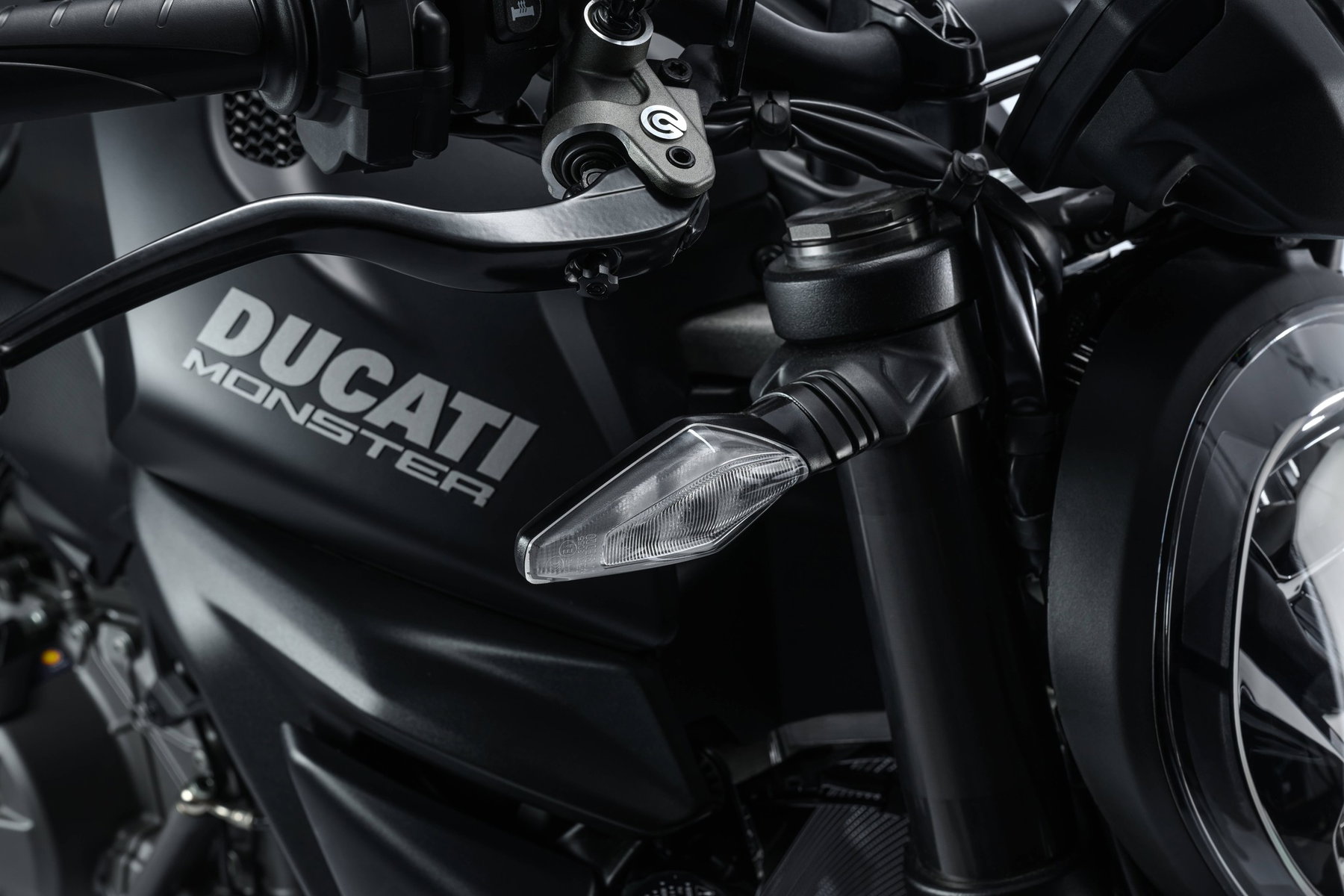 Ducati Monster Dark: Die günstigste Monster spart am Quickshifter 1 Ducati Monster Dark 2027 – Detail von Tankflanke, statischem LED-Blinker, Gabelbrücke und Brembo-Bremshebel