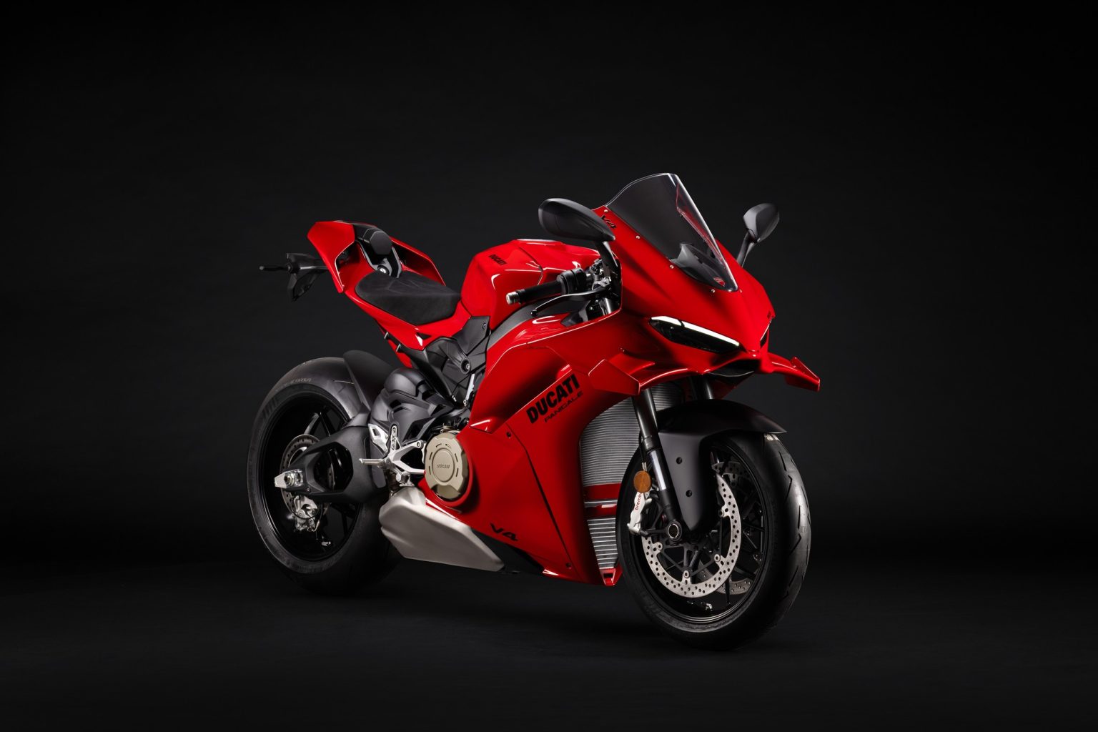2027 Ducati Panigale V4: More Revs, Softer Frame, Higher Price Ducati Panigale V4 2027 – in Ducati-Rot, Dreiviertelansicht von vorne rechts im dunklen Studio