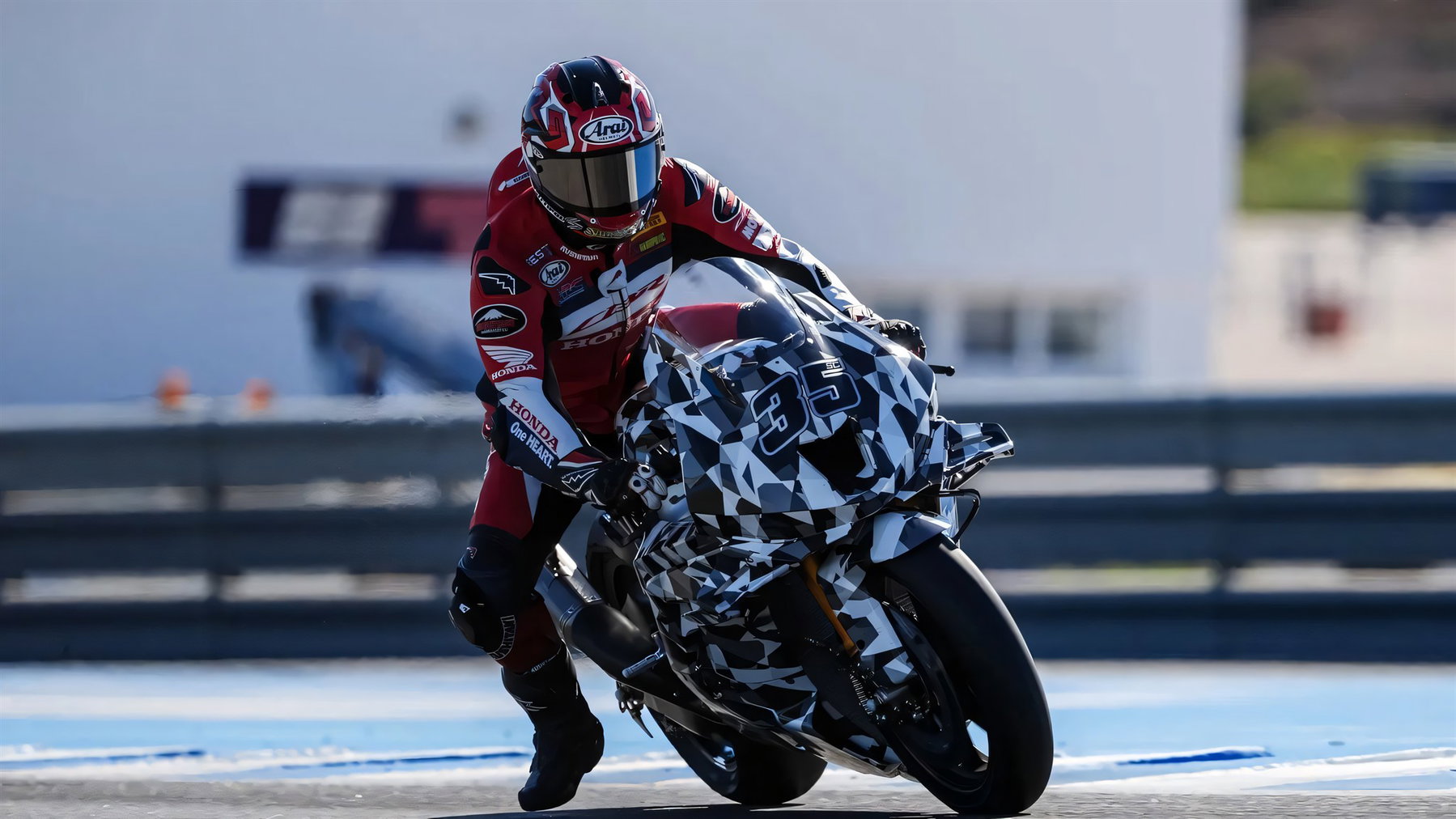 Somkiat Chantra in roter Lederkombi mit der getarnten Honda CBR1000RR-R Fireblade 2027 an der Boxengasse in Jerez
