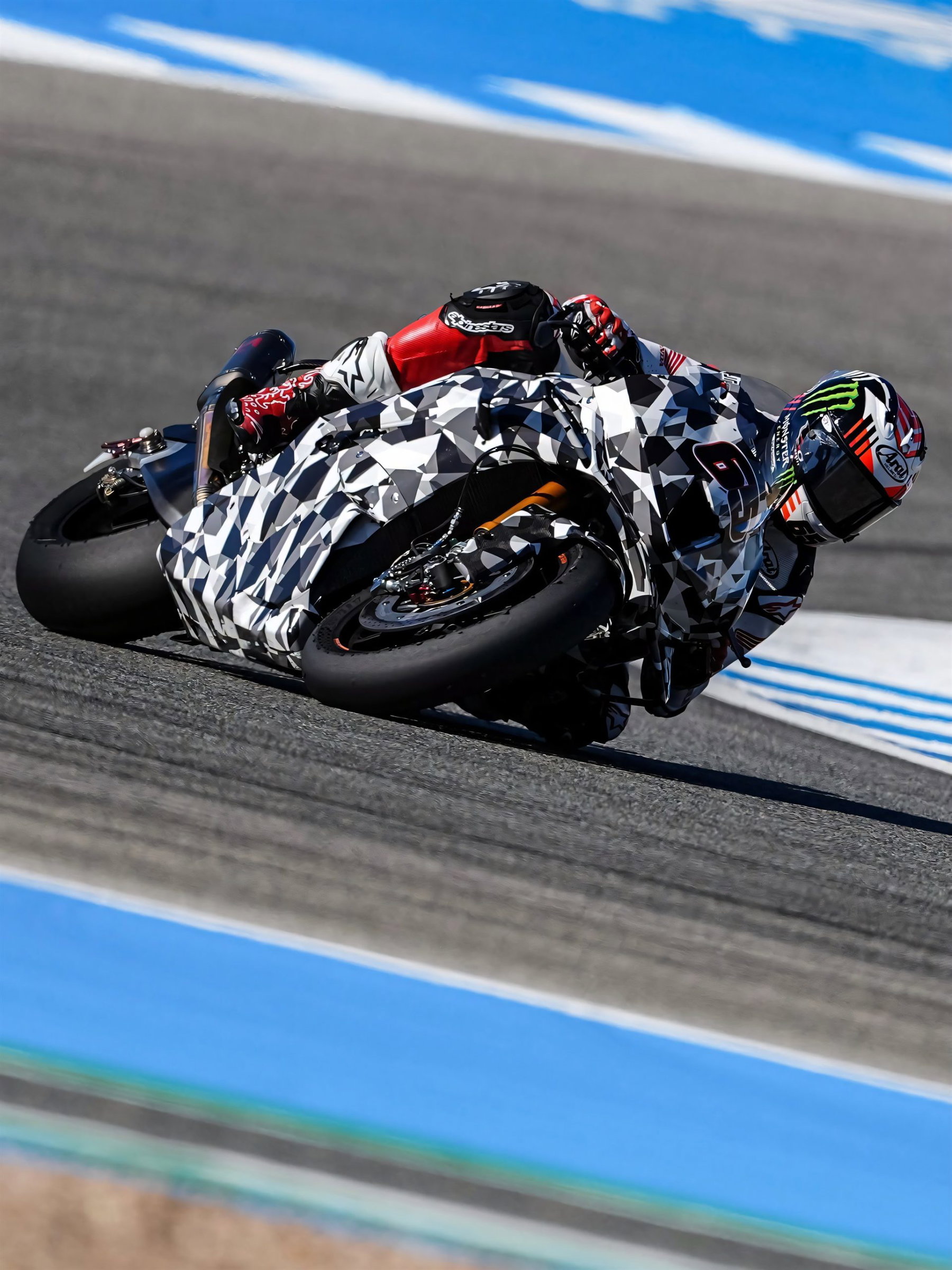 Jonathan Rea auf der getarnten Honda CBR1000RR-R Fireblade 2027 in tiefer Rechtskurve, blau-weiße Auslaufzone in Jerez