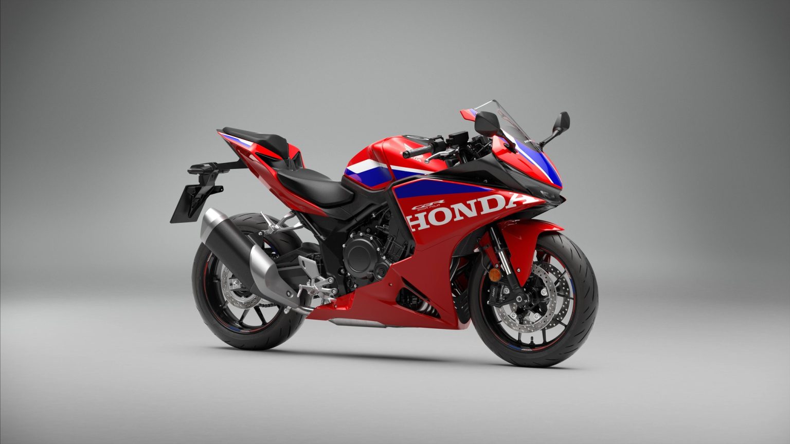 Honda CBR500R Four kommt nach Europa: Vierzylinder auch für A2-Fahrer Honda CBR500R FOUR 2027 in Ignition Red Tricolour – Studioaufnahme, Dreiviertelansicht von vorne rechts