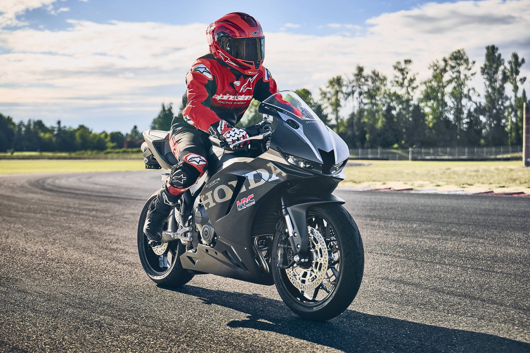 2027 Honda CBR600RR: Fireblade Brakes Keep the Four-Cylinder in the Race 5 Honda CBR600RR 2027 in Matt Ballistic Black Metallic mit Fahrer auf der Rennstrecke, Dreiviertelansicht von vorne