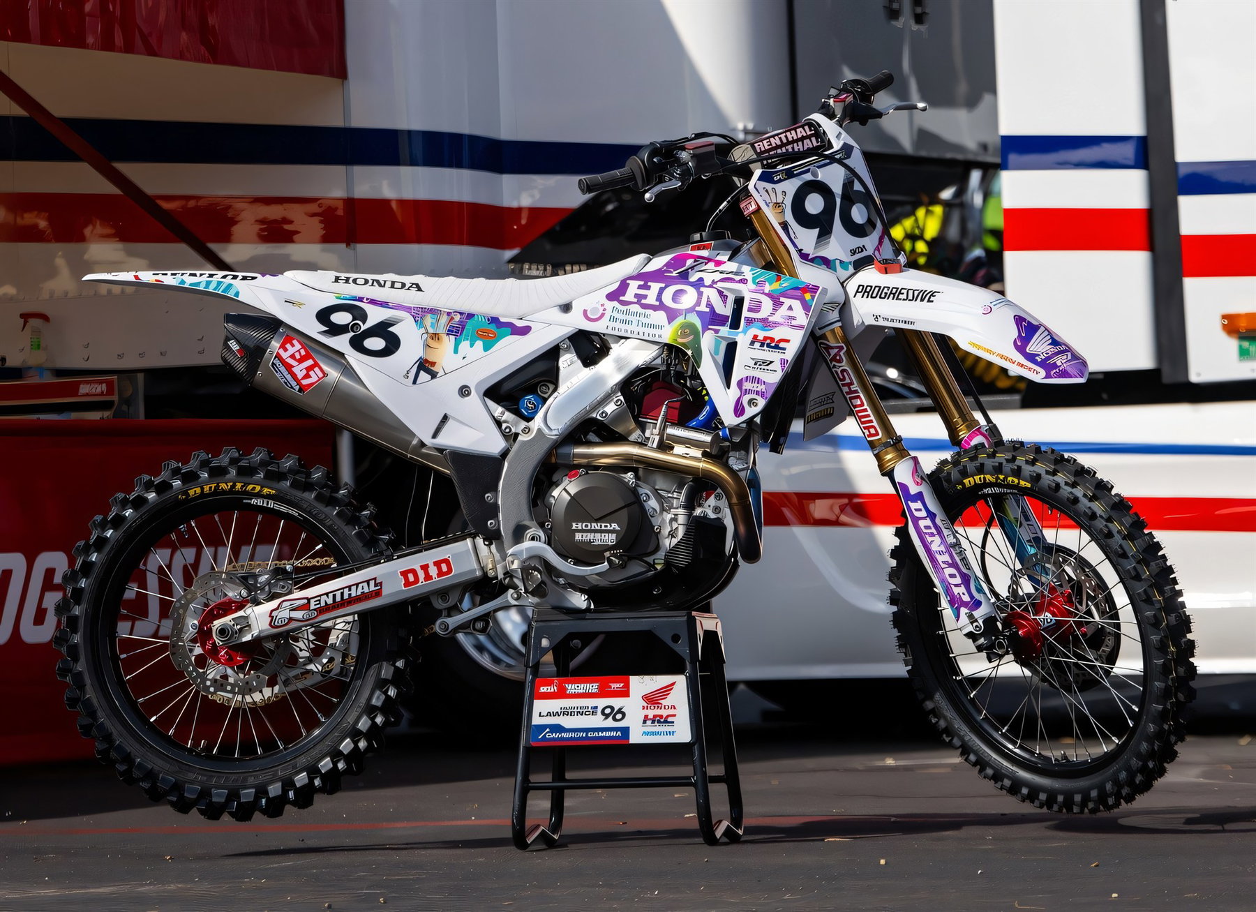Signed Honda Factory Parts From 30 Dollars: Auction Helps Children With Brain Tumors 4 Weiße Honda CRF450R Nr. 96 von Hunter Lawrence mit bunter Kinderzeichnungs-Sonderlackierung vor dem Honda-HRC-Truck im Fahrerlager Carson