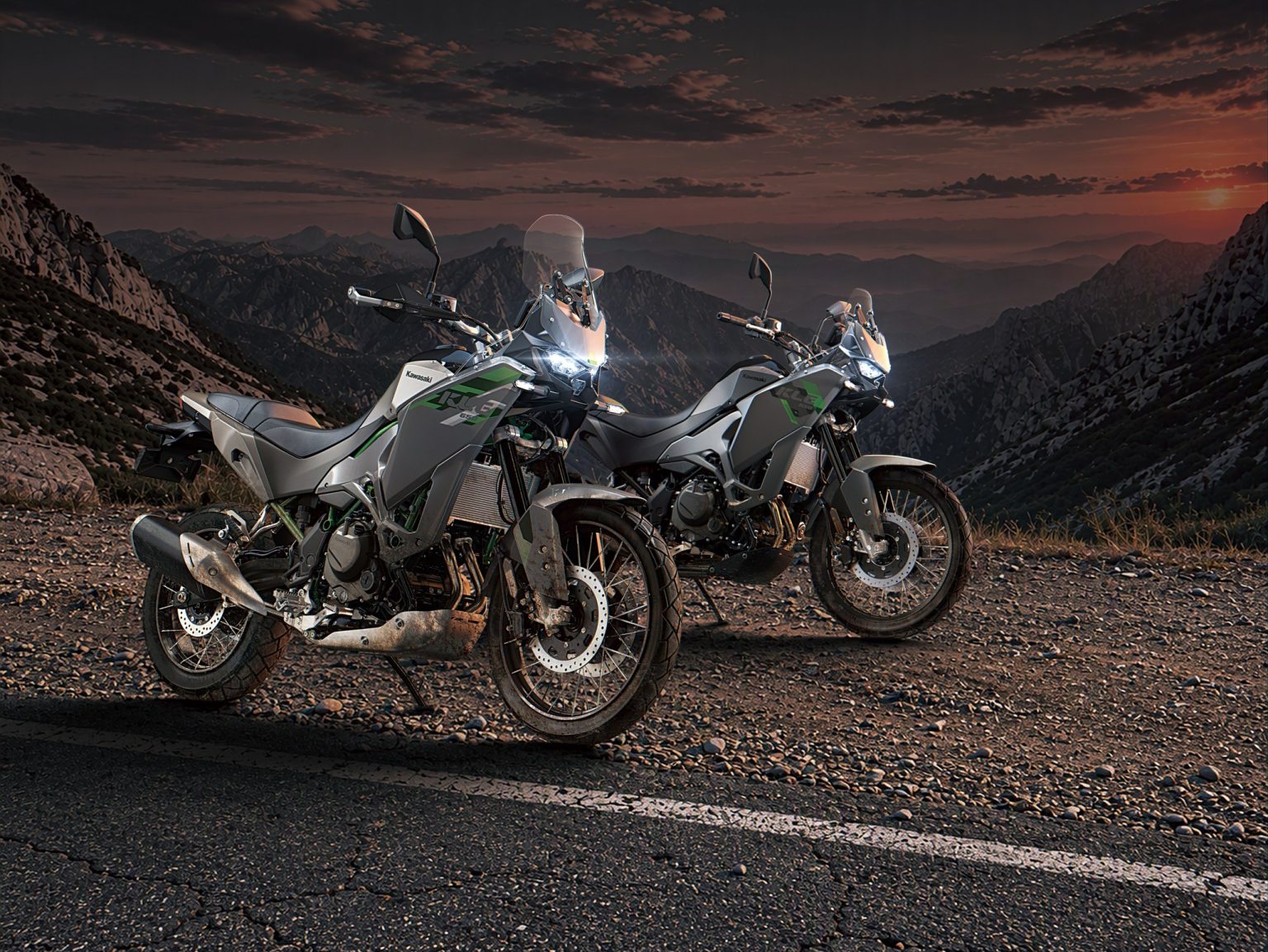Kawasaki KLE 650 offiziell: Mehr Reise als Rallye trotz 21-Zoll-Vorderrad Kawasaki KLE650 SE in Pearl Storm Gray und KLE650 in Metallic Matte Graphenesteel Gray nebeneinander auf einer Bergstraße bei Sonnenuntergang