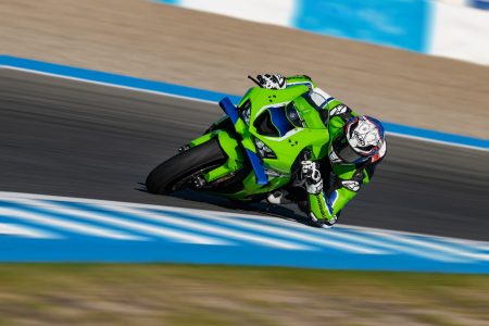 Kawasaki Ninja ZX-10R 2027 – Fahrer in tiefer Schräglage auf der Rennstrecke in Lime Green / Blue 24 mit Front-Winglets