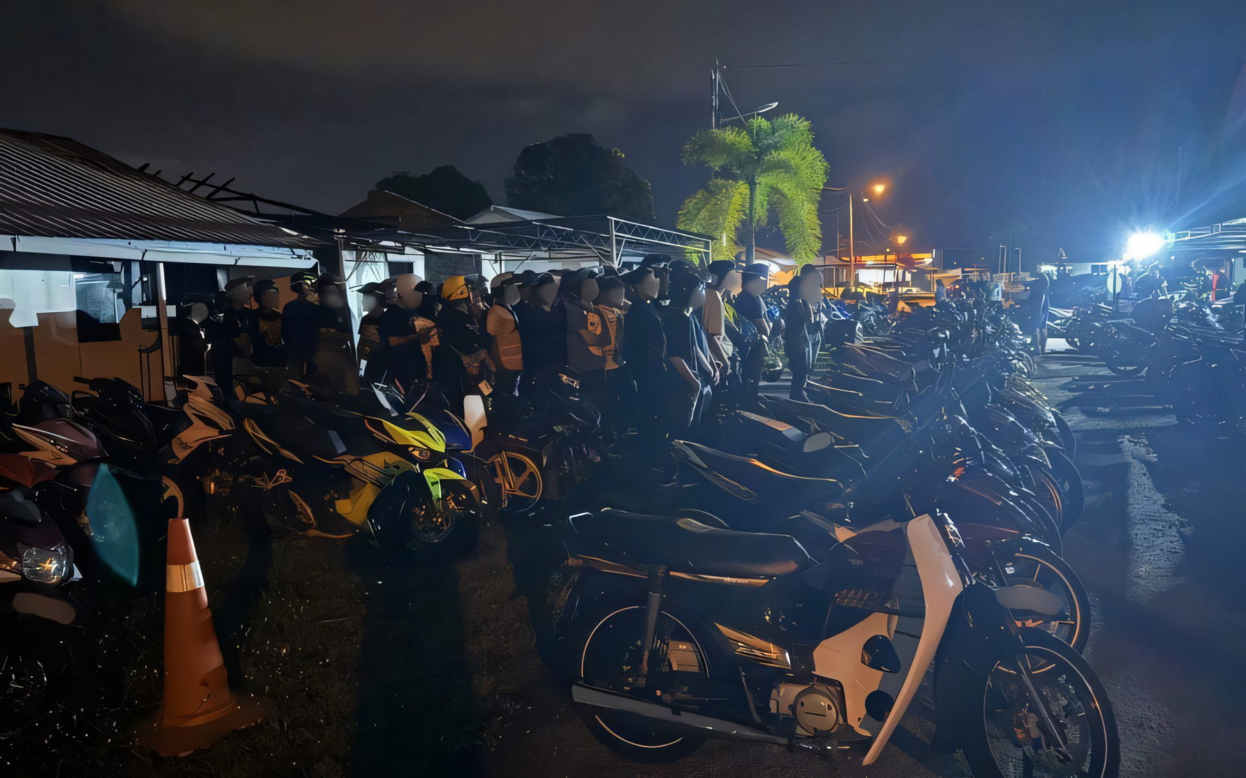 Mat Rempit in Penang: 30 Motorräder kassiert, ab November droht Haft 3 Bei der Polizeiaktion Op Samseng Jalanan am BORR in Butterworth beschlagnahmte Underbone-Motorräder in langen Reihen auf einem nächtlich beleuchteten Gelände, daneben Leitkegel
