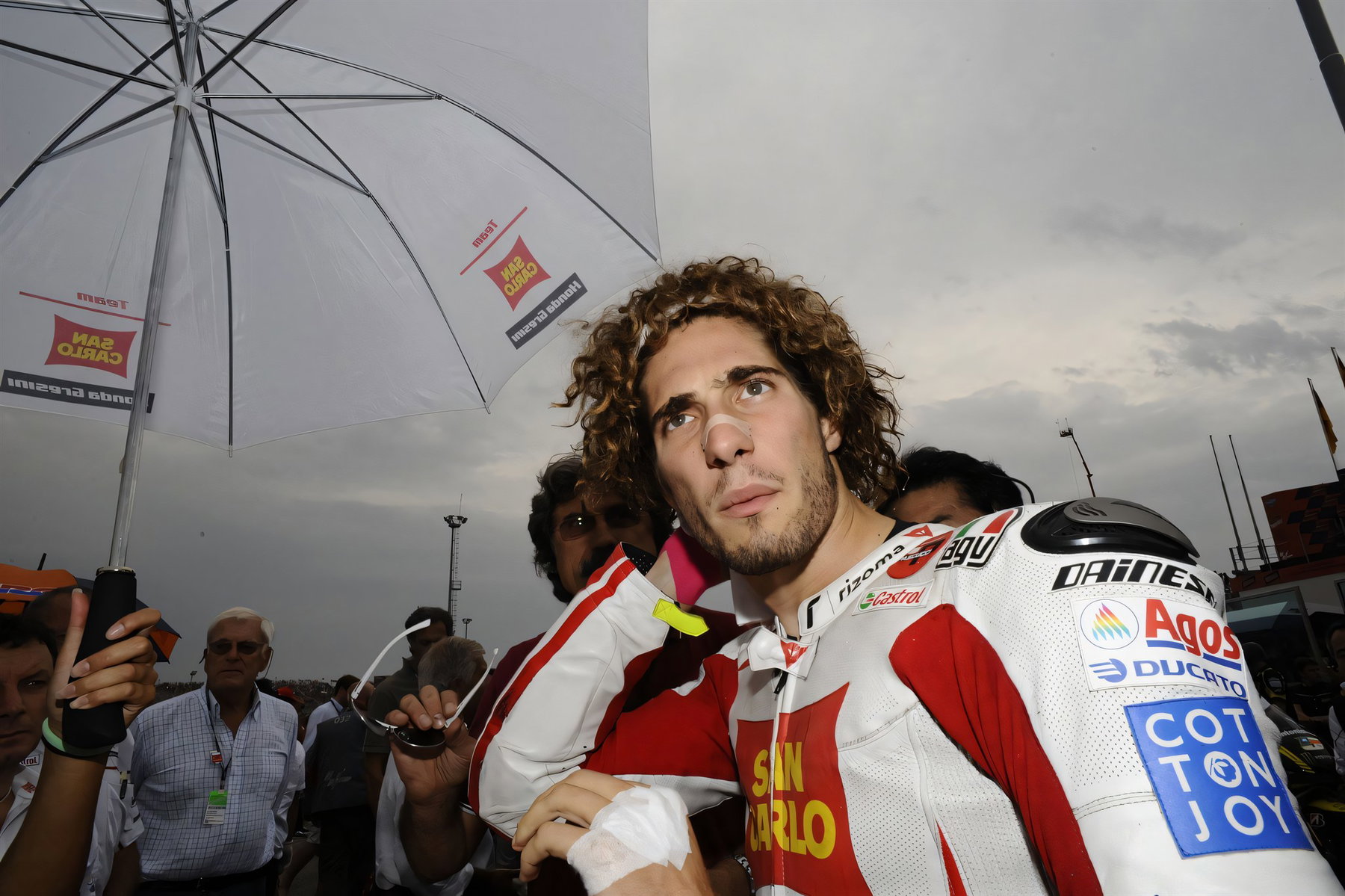 Michael Dunlop und Simoncellis Gilera: Was hinter dem Teaser steckt 4 Marco Simoncelli mit Lockenkopf in rot-weißer San-Carlo-Gresini-Lederkombi unter einem Schirm in der Startaufstellung