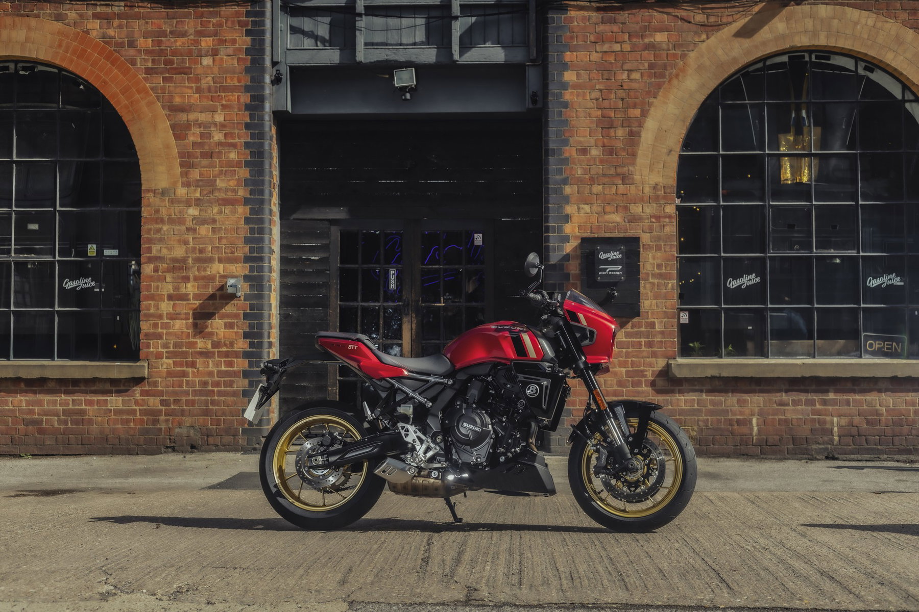 Suzuki GSX-8TT 2027: Rot-Gold-Look und Tempomat, die Technik bleibt 1 Suzuki GSX-8TT 2027 in Candy Daring Red, Seitenansicht vor einer Backsteinhalle mit großen Rundbogenfenstern