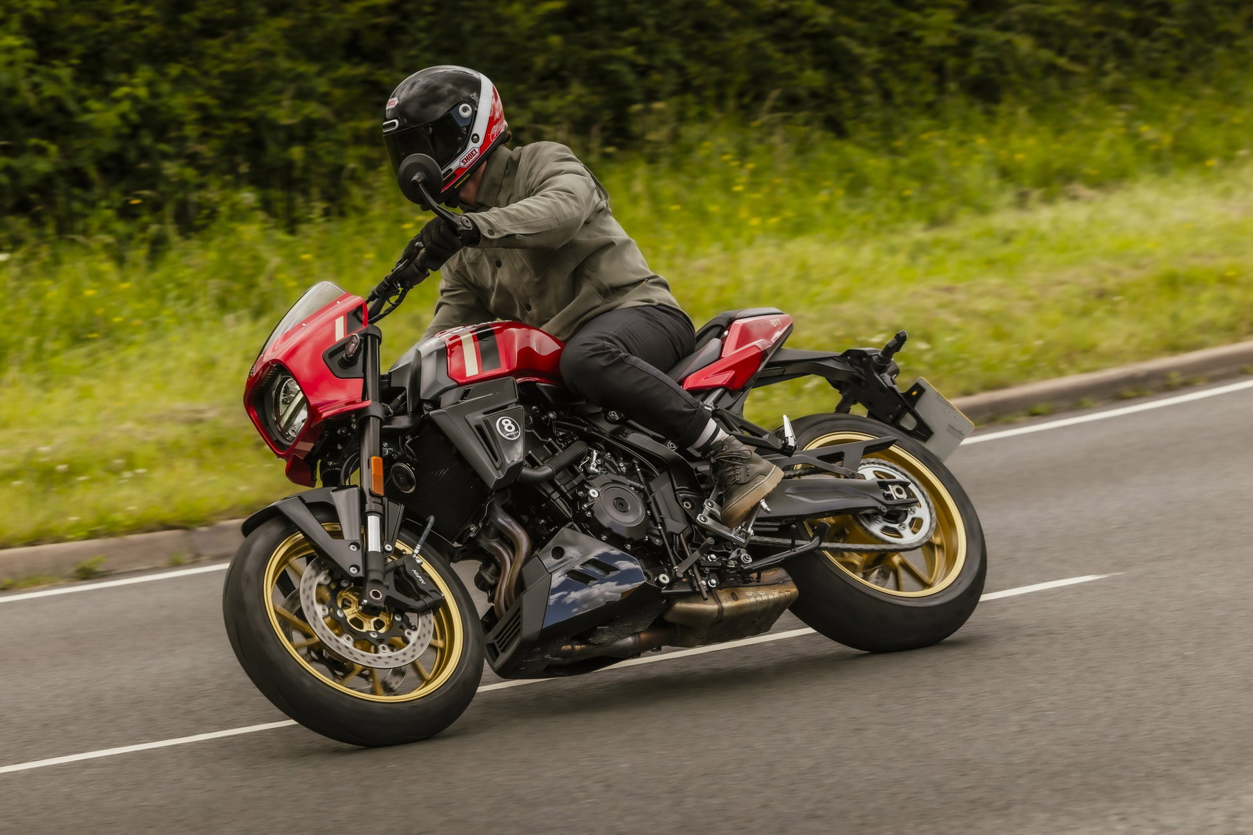 Suzuki GSX-8TT 2027: Rot-Gold-Look und Tempomat, die Technik bleibt 6 Suzuki GSX-8TT 2027 in Candy Daring Red mit goldenen Felgen in Schräglage auf einer Landstraße