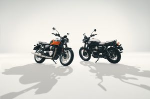 Triumph Bonneville T40 in Meriden Blue/Tangerine Orange und Bonneville T40 Black in Matt Pewter Grey stehen sich im hellen Fotostudio gegenüber