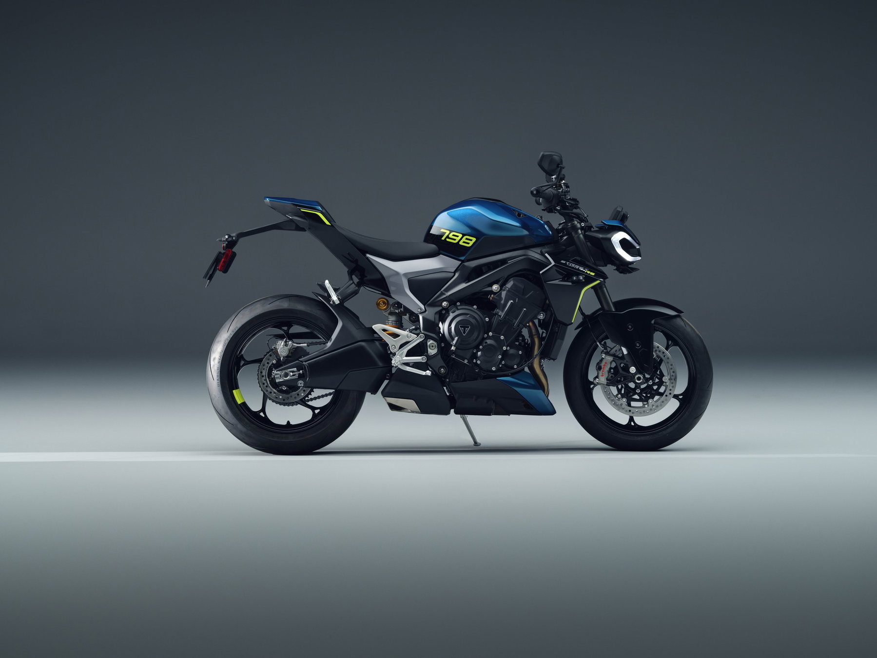 Triumph Neuheiten 2027: Was nach der Bonneville T40 noch kommt 4 Neue Triumph Street Triple 798 RS 2027 in Blau-Schwarz mit gelben Akzenten in der Seitenansicht von rechts im grauen Fotostudio
