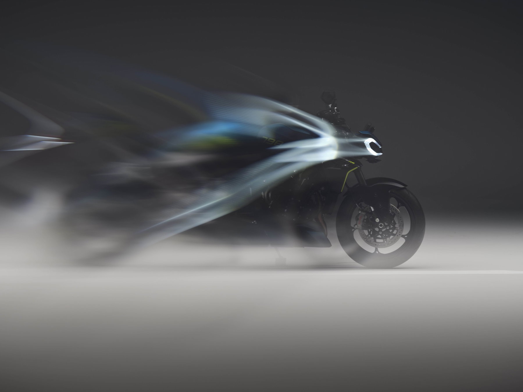 EICMA 2026: Wo in Mailand wirklich neue Motorräder enthüllt werden 3 Neue Triumph Street Triple 798 RS 2027 mit Bewegungsunschärfe und Lichtspuren im dunklen Studio, Teaserbild