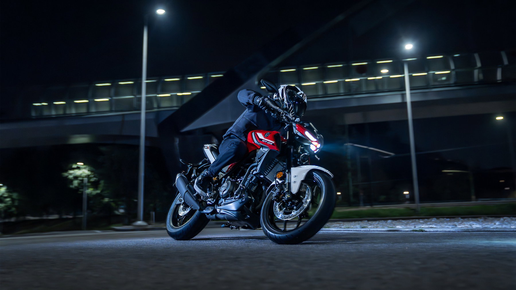 Yamaha 2027: New Colours for the Road, New Technology for the Dirt 3 Yamaha MT-03 2027 – in Redline in Schräglage bei Nacht in der Stadt