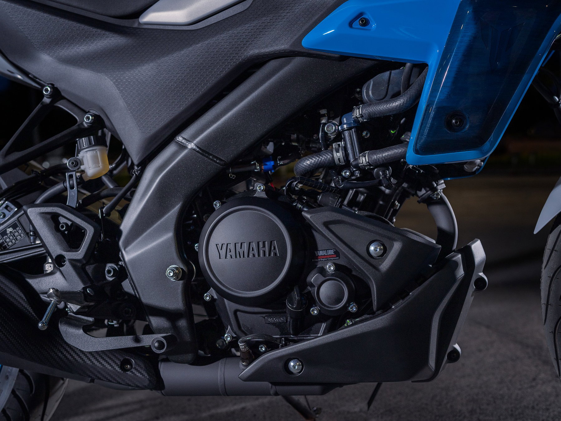 Yamaha MT-125 2027 – Detail des 125-cm³-Motors mit Yamaha-Schriftzug und Deltabox-Rahmen der MT-125 in Ice Storm (Silbergrau mit hellblauen Felgen)