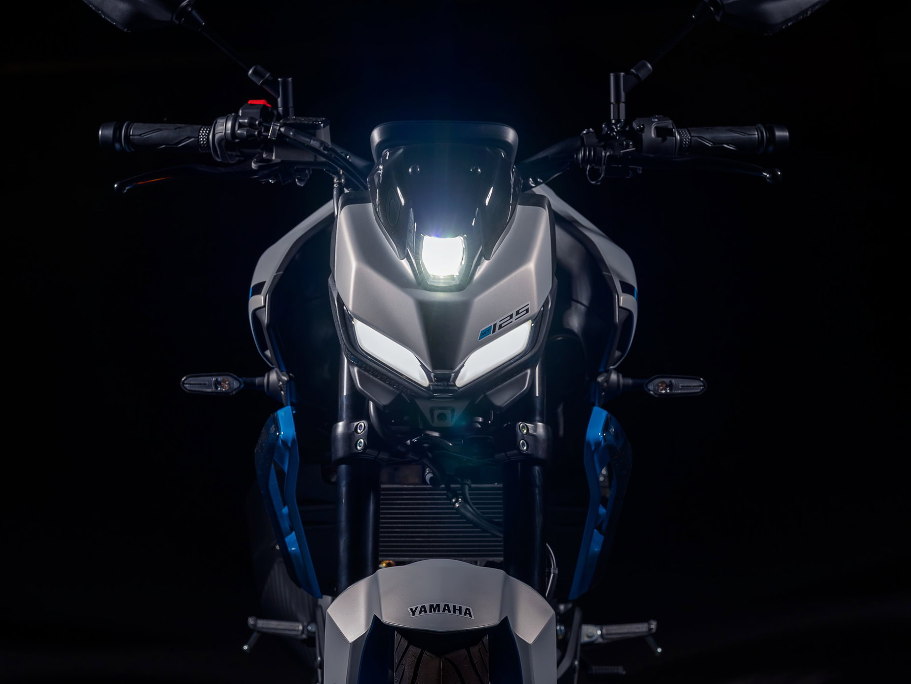 Yamaha MT-125 2027 – Detail der neuen Front mit klingenförmigen LED-Positionsleuchten und getönter Frontmaske der MT-125 in Ice Storm (Silbergrau mit hellblauen Felgen)