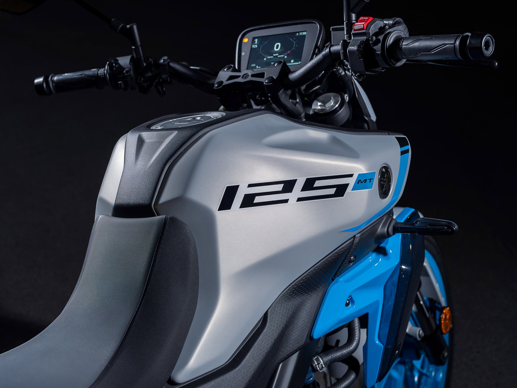 Yamaha MT-125 2027 – Detail des Tanks mit neuer 125er-Grafik und TFT-Display der MT-125 in Ice Storm (Silbergrau mit hellblauen Felgen)