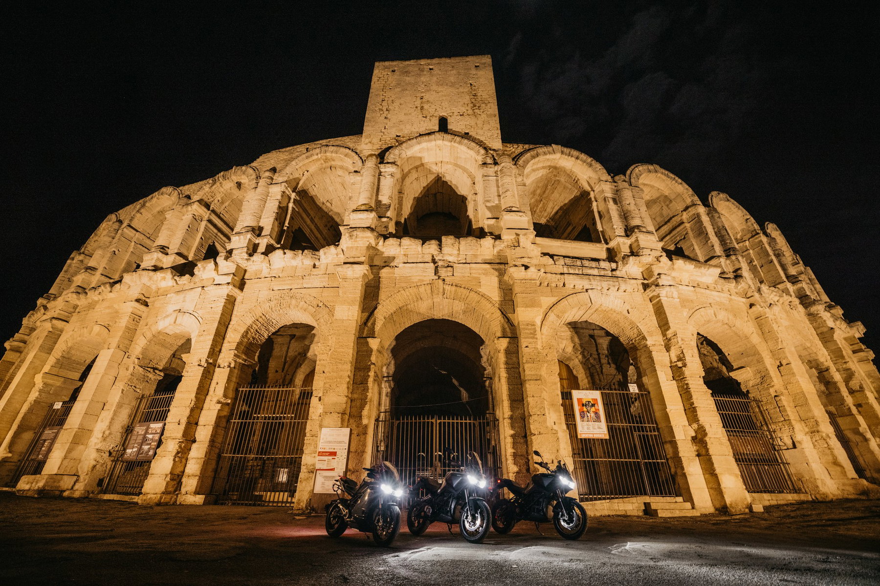 Zero DS fährt 436,5 km mit einer Ladung: So kam der Weltrekord zustande 6 Drei Zero-Elektromotorräder mit eingeschaltetem Licht vor dem nächtlich beleuchteten römischen Amphitheater von Arles