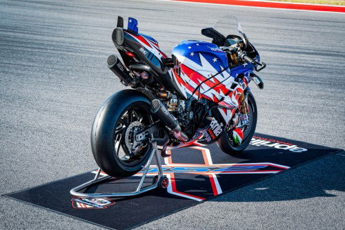 Aprilia X 250TH von hinten links mit SC-Project-Titan-Doppelauspuff und Pirelli-Slicks auf Aprilia-Racing-Matte – COTA Austin 2026