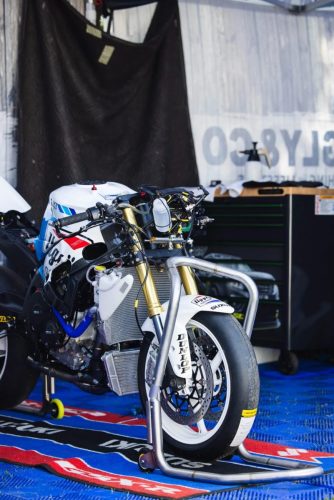 Suzuki Rennmaschine in Weiss-Blau im Dely and Co Paddock – Isle of Man TT 2026