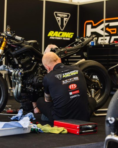 Triumph Racing Factory Team Mechaniker arbeitet an der Rennmaschine im Paddock – Isle of Man TT 2026