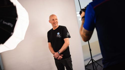 Fahrer im iHeat Outhwaite Racing Teamshirt beim offiziellen Fotoshooting – Isle of Man TT 2026 Scrutineering