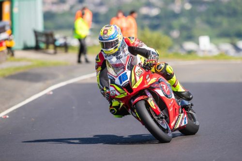 Startnummer 16 auf roter Honda mit neongelben Akzenten und Arai Helm in Schraglage – Isle of Man TT 2026 Free Practice