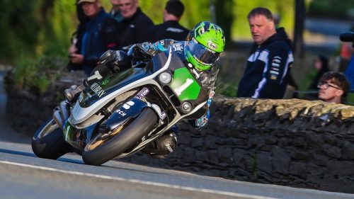 Mike Browne auf der Melbray Laycock Racing Paton in Schräglage an einer Steinmauer mit Zuschauern – Isle of Man TT 2026 Sportbike Qualifying