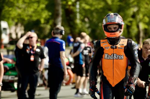 David Montgomery Mad Bros Racing steht im Fahrerlager der Isle of Man TT 2026 – Newcomers Speed Controlled Lap oranges RST-Leder mit Arai-Helm Klink Richard McGaw