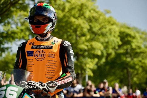 John Skelton Nr 56 stehend am Startplatz mit allen Sponsoren sichtbar – Micrometric Pell Plant Hire Doughty Cakes Slipstream Motorcycles Isle of Man TT 2026 Newcomers