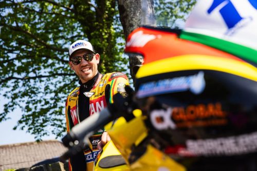 Peter Hickman mit Sonnenbrille und Levy Cap in gelb-schwarzer Teamkleidung – Isle of Man TT 2026 Paddock