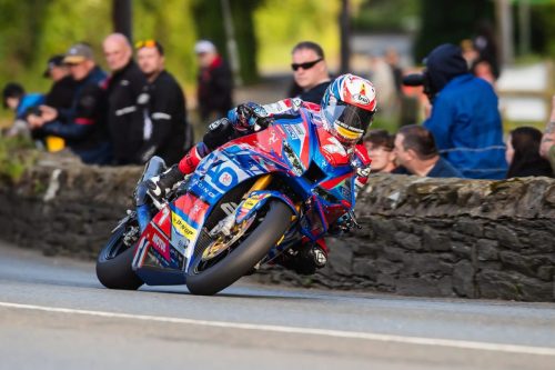 Peter Hickman auf der 8TEN Racing BMW Nummer 10 in Schräglage vor Zuschauern an Steinmauer – Isle of Man TT 2026 Qualifying