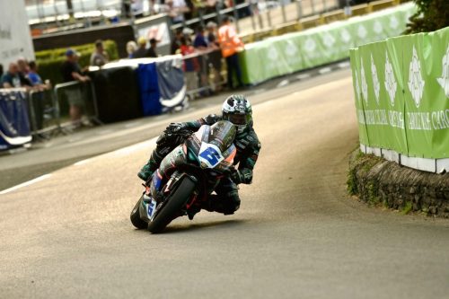 Michael Dunlop auf der Hawk Racing Honda in Schräglage im Startbereich vor Carole Nash Banner – Isle of Man TT 2026 Qualifying