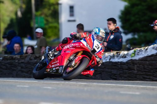 Dean Harrison auf der Honda Racing UK Nummer 3 in Schräglage vor weißem Haus und Zuschauern – Isle of Man TT 2026 Qualifying