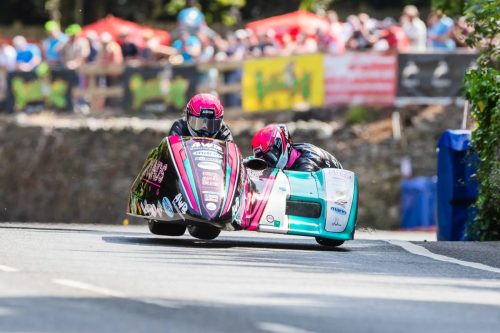 Pete Founds und Jevan Walmsley im AWB-Sidecar mit rosa Helmen in Schräglage – Isle of Man TT 2026 Qualifying