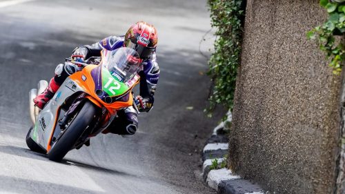 Joe Yeardsley auf der orange-violetten Flitwick-Yamaha in tiefer Schraeglage neben einer Steinmauer auf dem Mountain Course - Sportbike TT Race 1, Isle of Man TT 2026