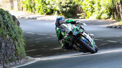 David Johnson auf der CD Racing Kawasaki in Schräglage entlang von Steinmauern und Bäumen – Superbike TT Isle of Man 2026