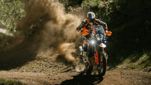 KTM 890 Adventure R Rally 2026 in Fahrt auf Schotterweg mit grosser Staubwolke – Frontansicht Offroad