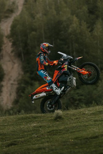 KTM 890 Adventure R Rally 2026 beim Wheelie auf Wiese – Hochformat Seitenansicht Offroad