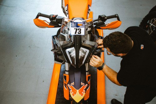 KTM 890 Adventure R Rally 2026 Cockpit von oben mit Startnummer 73 und Mechaniker – Detailansicht Vogelperspektive