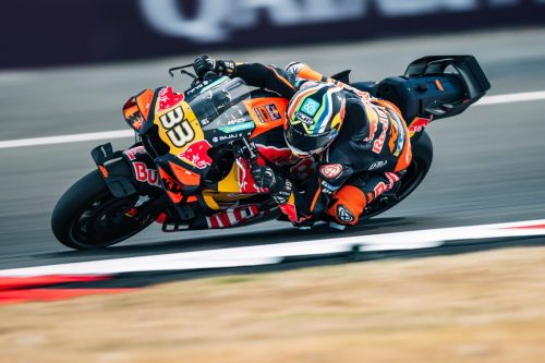 Brad Binder hängt in tiefer Schräglage neben der KTM RC16 mit der Startnummer 33 – MotoGP Großbritannien GP Silverstone 2026