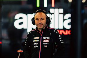 Teammitglied von Aprilia Racing mit Headset in der Box vor der beleuchteten Aprilia-Wand – MotoGP San-Marino-GP Misano 2026