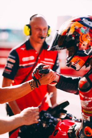 Luca Marini im Helm beim Handschlag mit einem Teammitglied in der Boxengasse – MotoGP San-Marino-GP Misano 2026