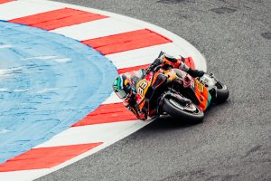 Brad Binder mit der Startnummer 33 in Schräglage über die Randsteine, Aufnahme aus der Vogelperspektive – MotoGP San-Marino-GP Misano 2026