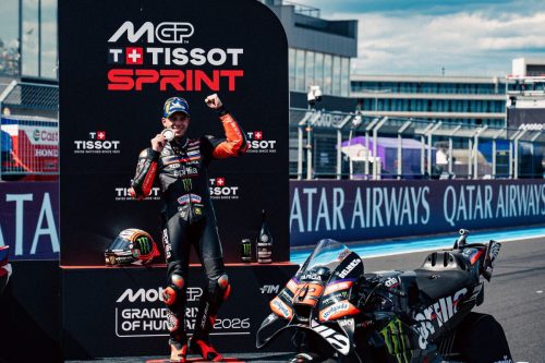 Marco Bezzecchi feiert mit Medaille neben seiner Aprilia RS-GP26 am Tissot-Sprint-Board – MotoGP Ungarn GP Balaton Park 2026